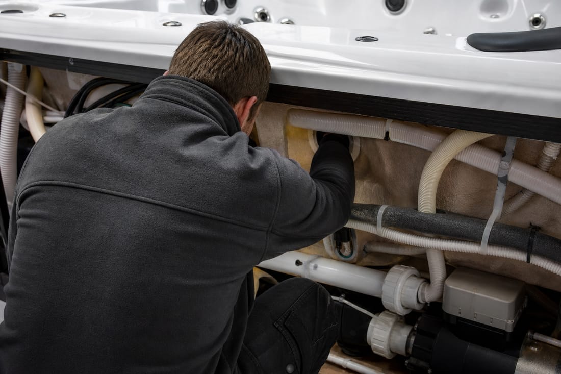 Beispiel: Techniker prüft Dichtungen am Whirlpool, von hinten